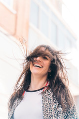 Beautiful happy brunette woman smiling outdoors on city street.