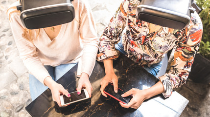 Girl friends playing on vr glasses outdoor - Virtual reality and wearable tech concept with young...