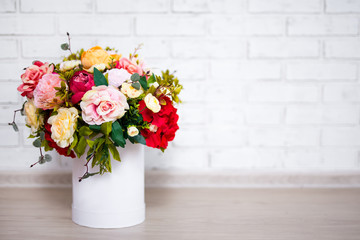beautiful bunch of summer flowers in round box with copy space over white wall background