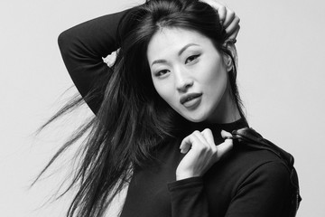 Fashionable asian model in black leather jacket posing. studio shot. black and white