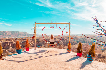 Carefree woman on the swing. Inspiring mountains landscape.