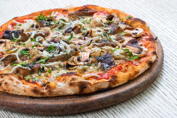 Pizza with mushrooms on a wooden board. On white background.