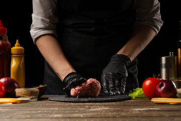 Chef prepares a meat patty with minced meat for a burger. Delicious and unhealthy food. Horizontal photo, Taste food concept