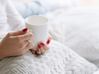 Wake up drink. Woman hands with white cup of hot morning beverage.