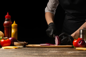 The cook cuts the red onions for marinating the burger, the burger recipe. Cooking recipe, making a juicy hamburger, menu, homemade recipes. Horizontal photos