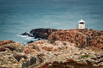 Fototapeta na wymiar White lighthouse on cliffs