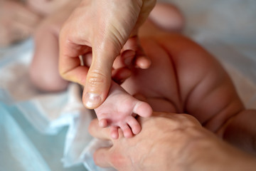 Image from above of kid’s feet and hands of man masseur.