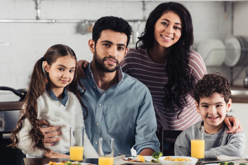happy hispanic family smiling while looking at camera at home