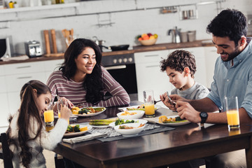 happy hispanic family smiling while having lunch at home