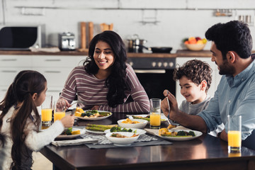 cheerful hispanic family having lunch at home - Powered by Adobe