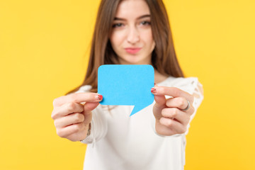 Feedback concept. Assessment survey. Young attractive female holding speech bubble with copy space.