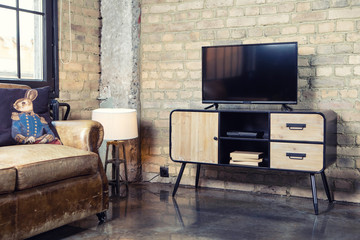 TV in the interior in retro loft style on the bedside table with decorative items