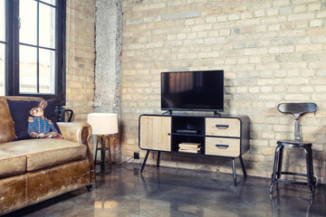 TV in the interior in retro loft style on the bedside table with decorative items