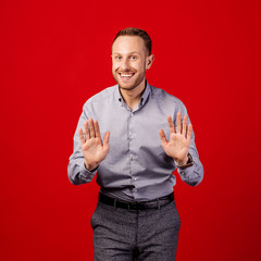 man making stop gesture over red background. emotion and people concept