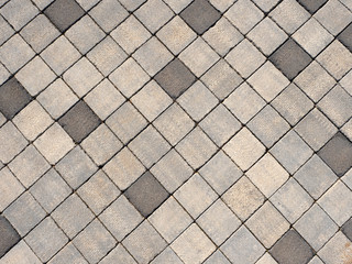 Skilful paving of square blocks of gray shades in daylight.