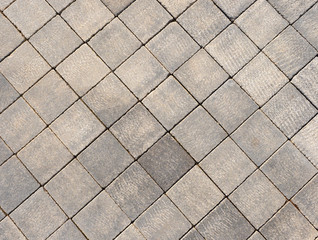 Fragment of square stone blocks of gray stone on a pedestrian sidewalk