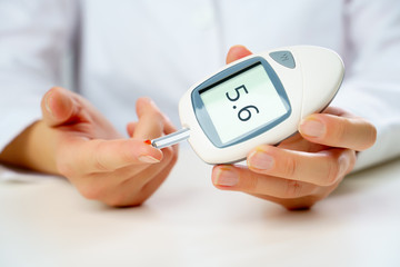 Photo of patient's hand with glucometer.