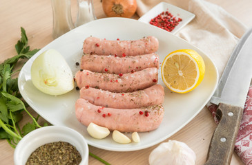 raw sausages, pork sausages on a plate, spices,