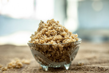 Close up of popular Indian & Asian sweet dish i.e. Malida or churma na ladu or moti chur na ladu in a bowl on brown surface.