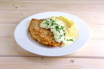 Chopped cutlet in breading with mashed potato and cream sauce