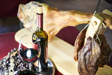 Bottle of wine with glass and ham