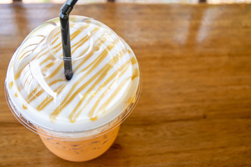  Iced tea with milk cream. Thai ice tea on wooden background with space
