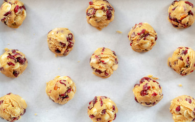 cranberry white chocolate cookies dough on white baking paper prepare for bake