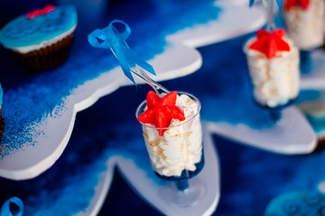 Desserts with whipped cream and sea star décor. Candy bar for party, birthday, wedding. Background for prints, cards, banners