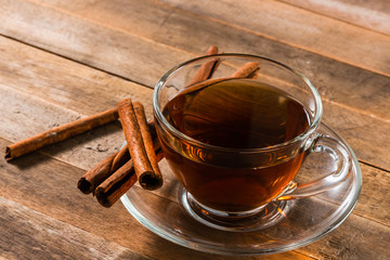 a cup of cinnamon tea on wooden table - Powered by Adobe