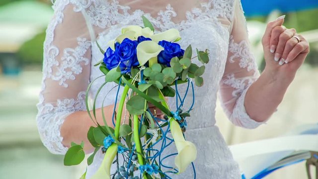 The bride is holding a beautiful bouquet. Her dress is also very stunning.