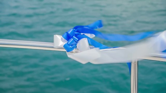 Blue and white ribbon is flapping in the wind. The day is sunny and warm.