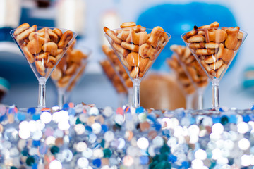 Candy bar for kids party. Snacks, cookies fish shaped on the elegant glasses. Summer season delicious on the party