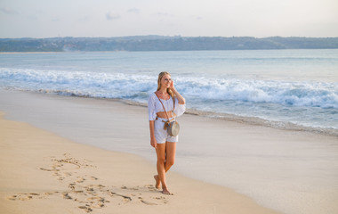 Girl in white shorts and t-shirt on the ocean beach