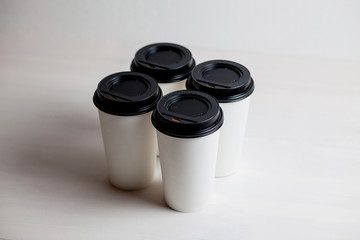 Coffee in blank white paper cups takeaway with caps. on white background.