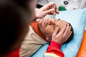 Cropped view of paramedic doing eye examining with patient