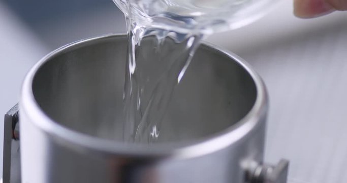 Pouring a chemical fluid into a metal container