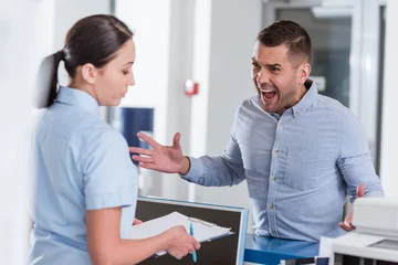 Fotobehang Aggressive man yelling at nurse in clinic © LIGHTFIELD STUDIOS
