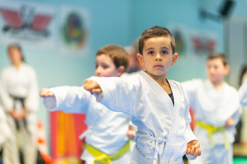 Children trying new martial moves in practice during karate class in gym interior © jovannig
