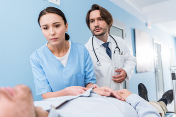 Worried doctors with stethoscope looking at patient