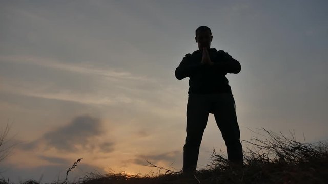 man martial arts concept. male warrior monk practicing kung fu. silhouette of a man at sunset engaged in martial lifestyle arts karate