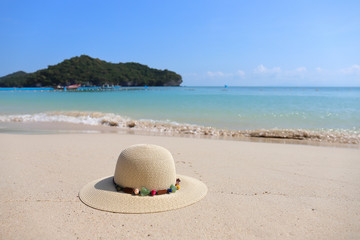 Fototapeta na wymiar Summer hat on the tropical sand beach.
