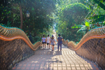 Chiang Mai, Thailand - May 3, 2017: Tourist are walking down the naga stairs after worship to the golden chedi at Wat Phra That Doi Suthep, the famous temple and became the landmark of Chiang Mai. - obrazy, fototapety, plakaty