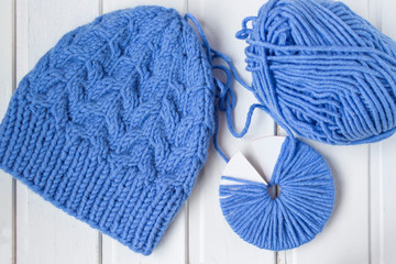 Woolen yarn ball. Future pompon on the white wooden background