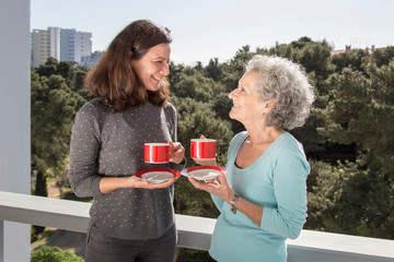 Portrait of two pretty women, mother and daughter, drinking tea