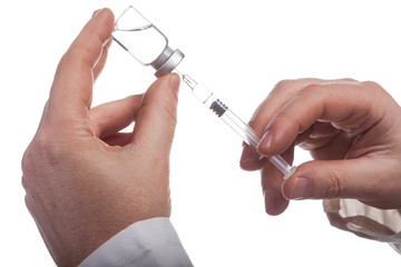 A syringe and a bottle with an injection solution on white background.