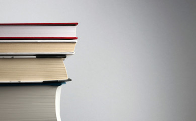 Education concept. Bookshelf with stack of important books on grainy grey background