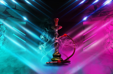 Hookah with smoke on the background of a concrete pavement with multi-colored laser beams, neon light, smoke