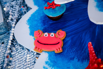 Homemade homemade gingerbread cookies in the form of crab, turtile, octopus and a starfish on the wooden table. Space for text and selective focus