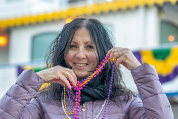 Woman happy for New Orleans Mardi Gras, holding beads and smiling
