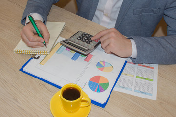 closeup pen on paperwork accounts with man use calculator. accounting concept. Man hand with pen, calculator